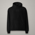 Hoodie Oversize Molleton BTY sur fond studio béton.