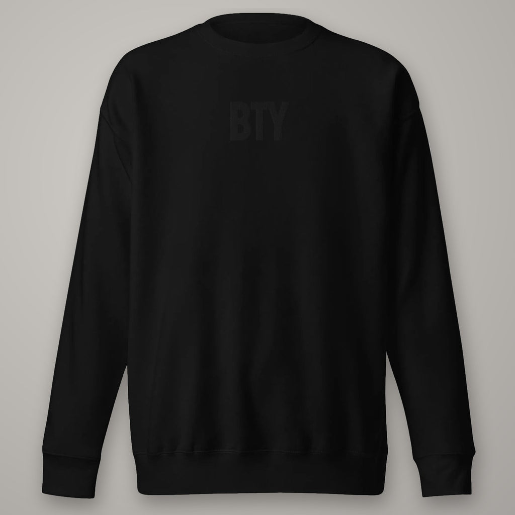 Sweat Col Rond Premium BTY sur fond studio béton.