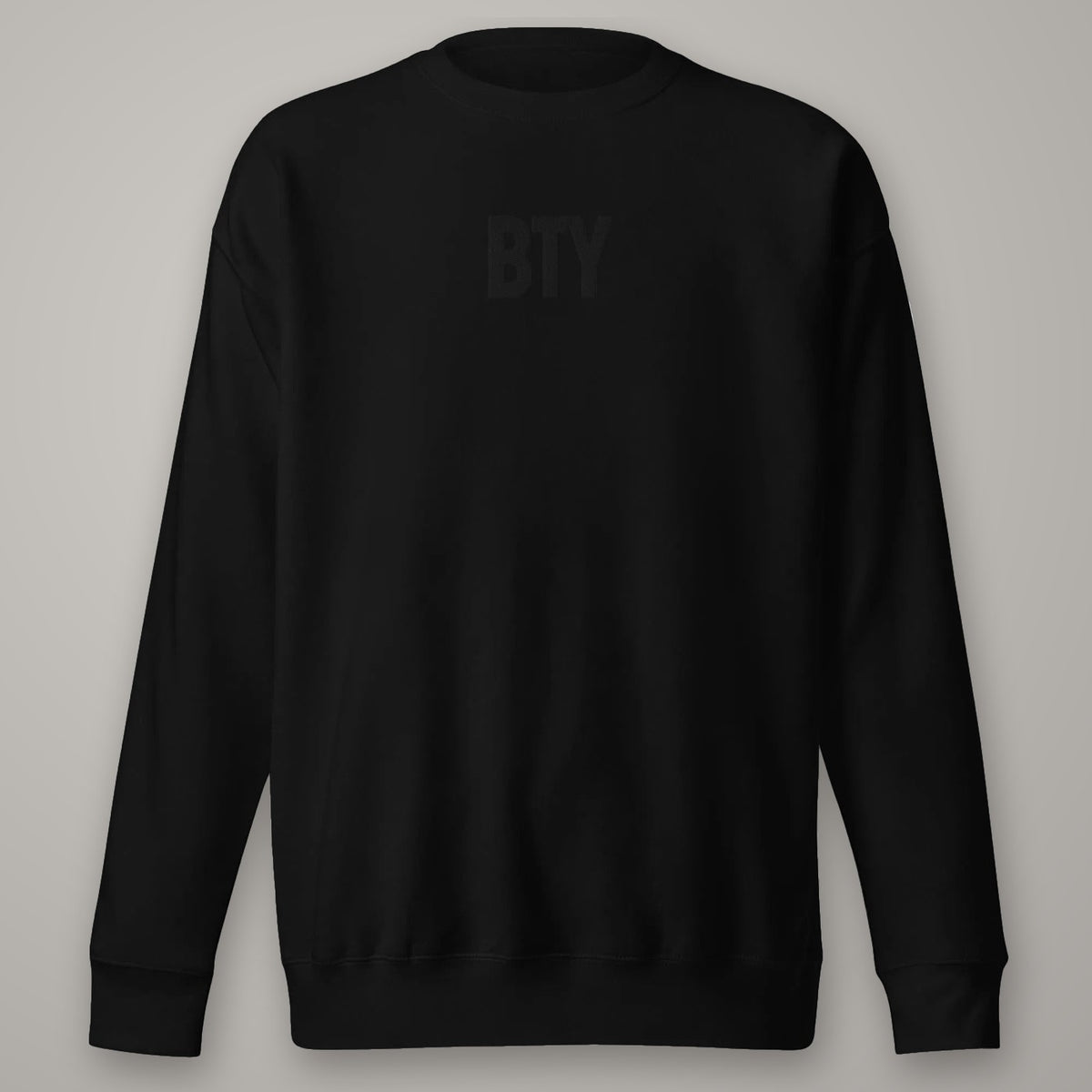 Sweat Col Rond Premium BTY sur fond studio béton.