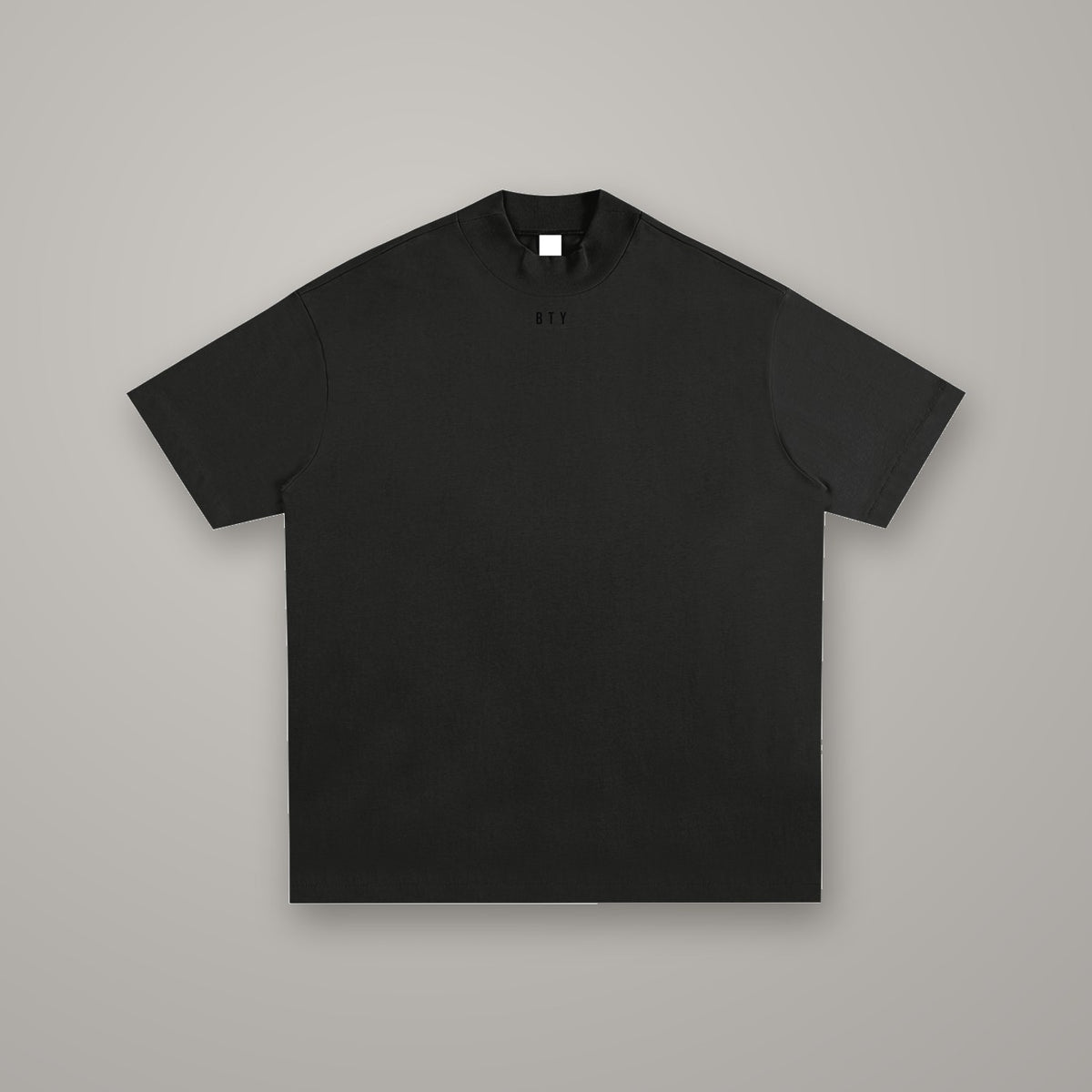 Tee Coton Carrure Tombante BTY, coloris Noir Combat, sur fond studio béton.