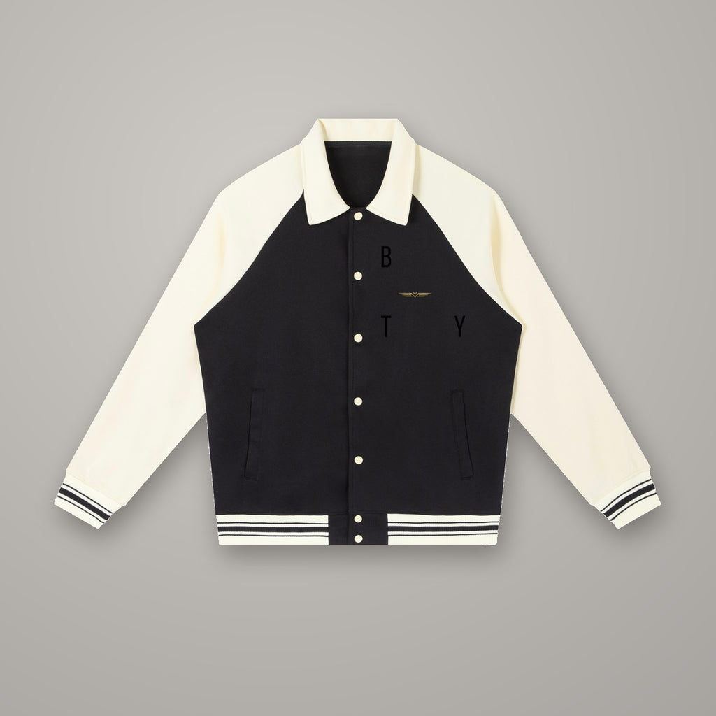 Veste Baseball Raglan BTY, coloris Noir Combat & Abricot, sur fond studio béton.