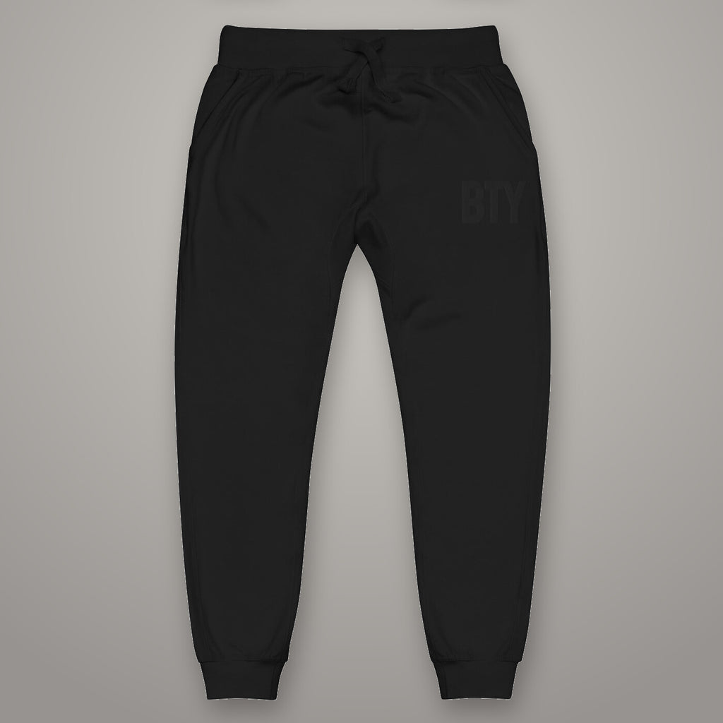 Joggers « Discipline » BTY, Noir Combat, sur fond studio béton.