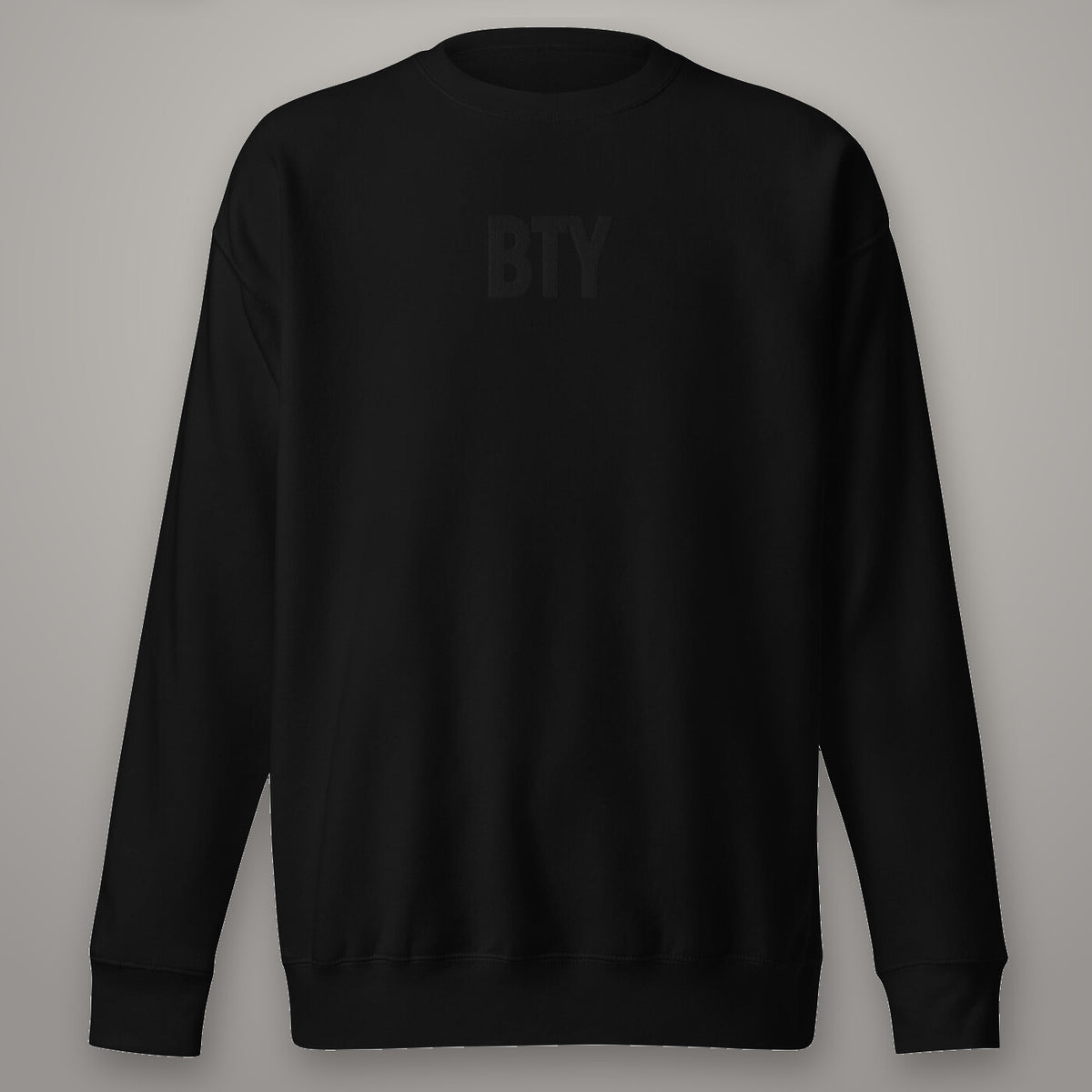 Crewneck « Carbon » BTY, Noir Combat, sur fond studio béton.