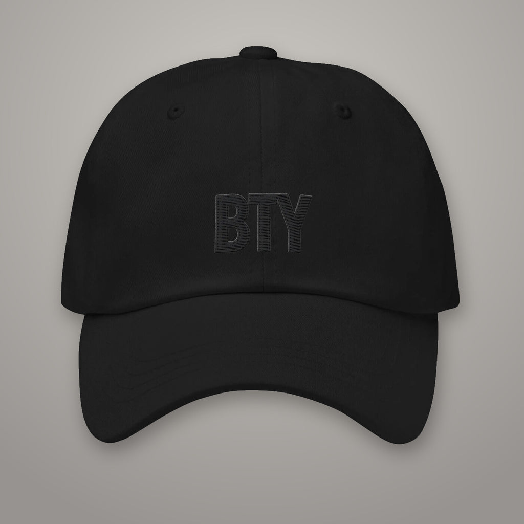 Casquette « Glyph » BTY, Noir Combat, sur fond studio béton.