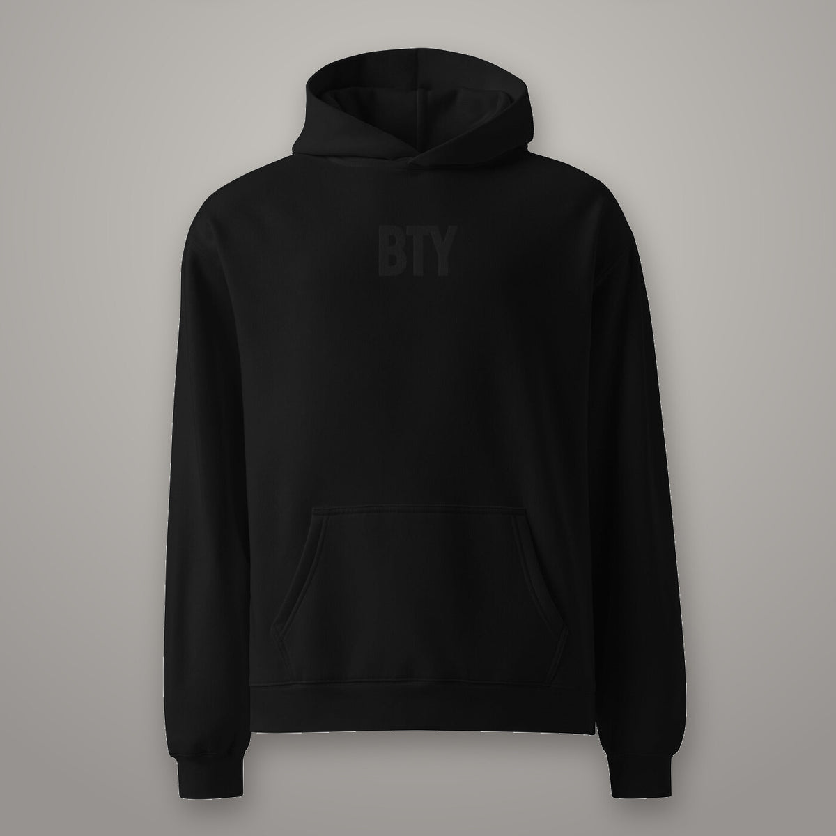 Hoodie « Champion » BTY, Noir Combat, sur fond studio béton.