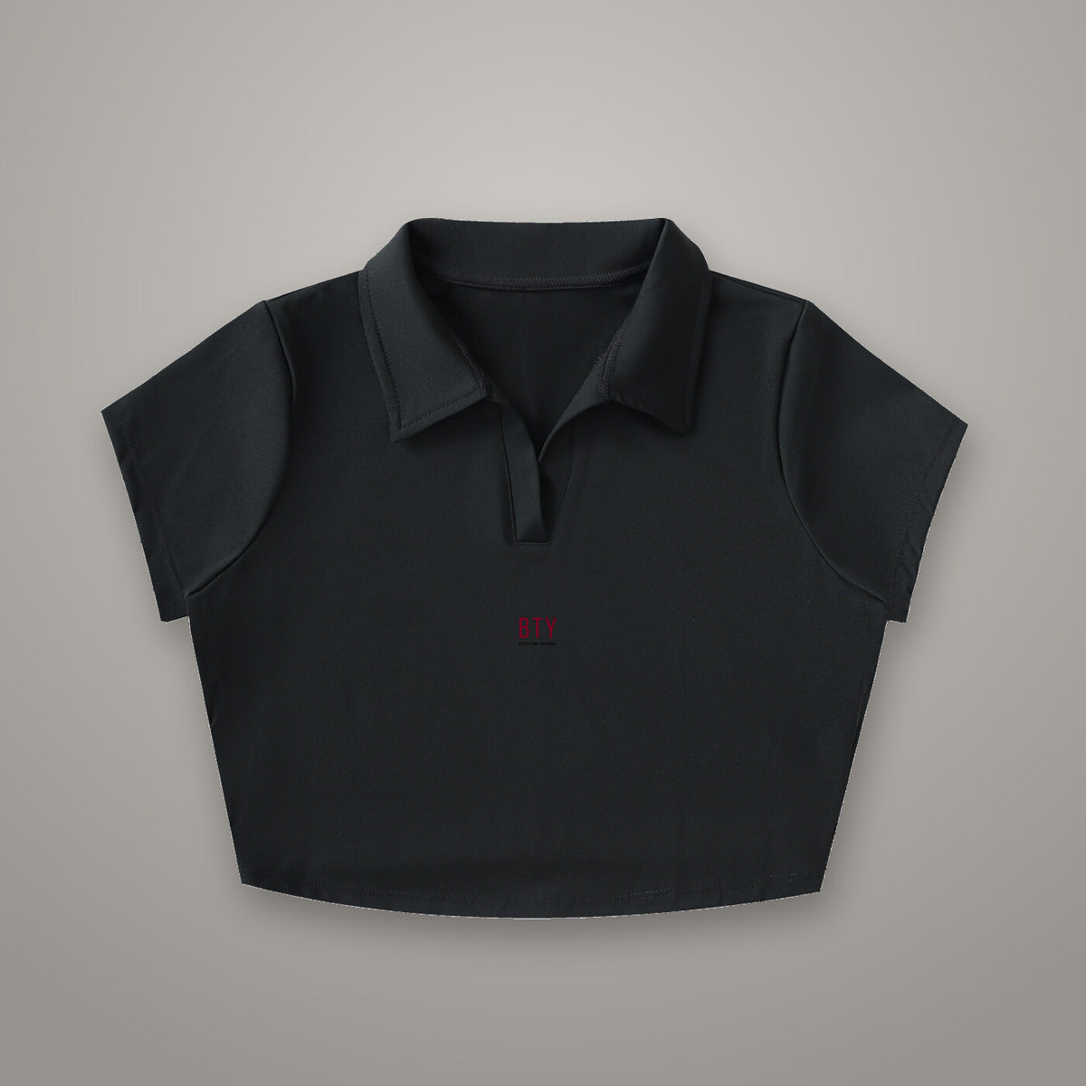 Crop Polo Col V BTY, marquage Signature Rouge, sur fond studio béton.